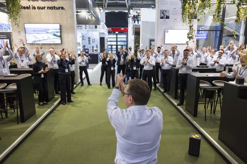 The BAU stand crew cheering at the booth.