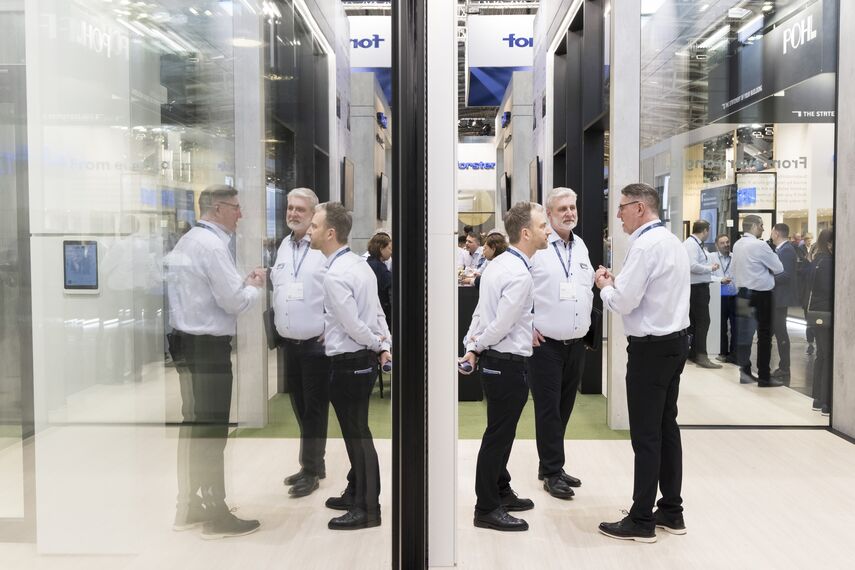 Reynaers Aluminium sales representatives talking at the BAU booth.